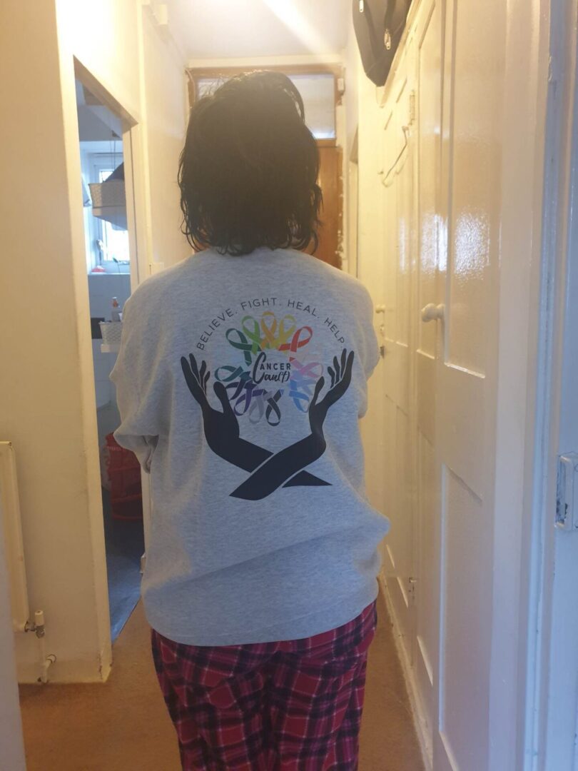 Person wearing a white shirt with a colorful graphic and black birds on the back.
